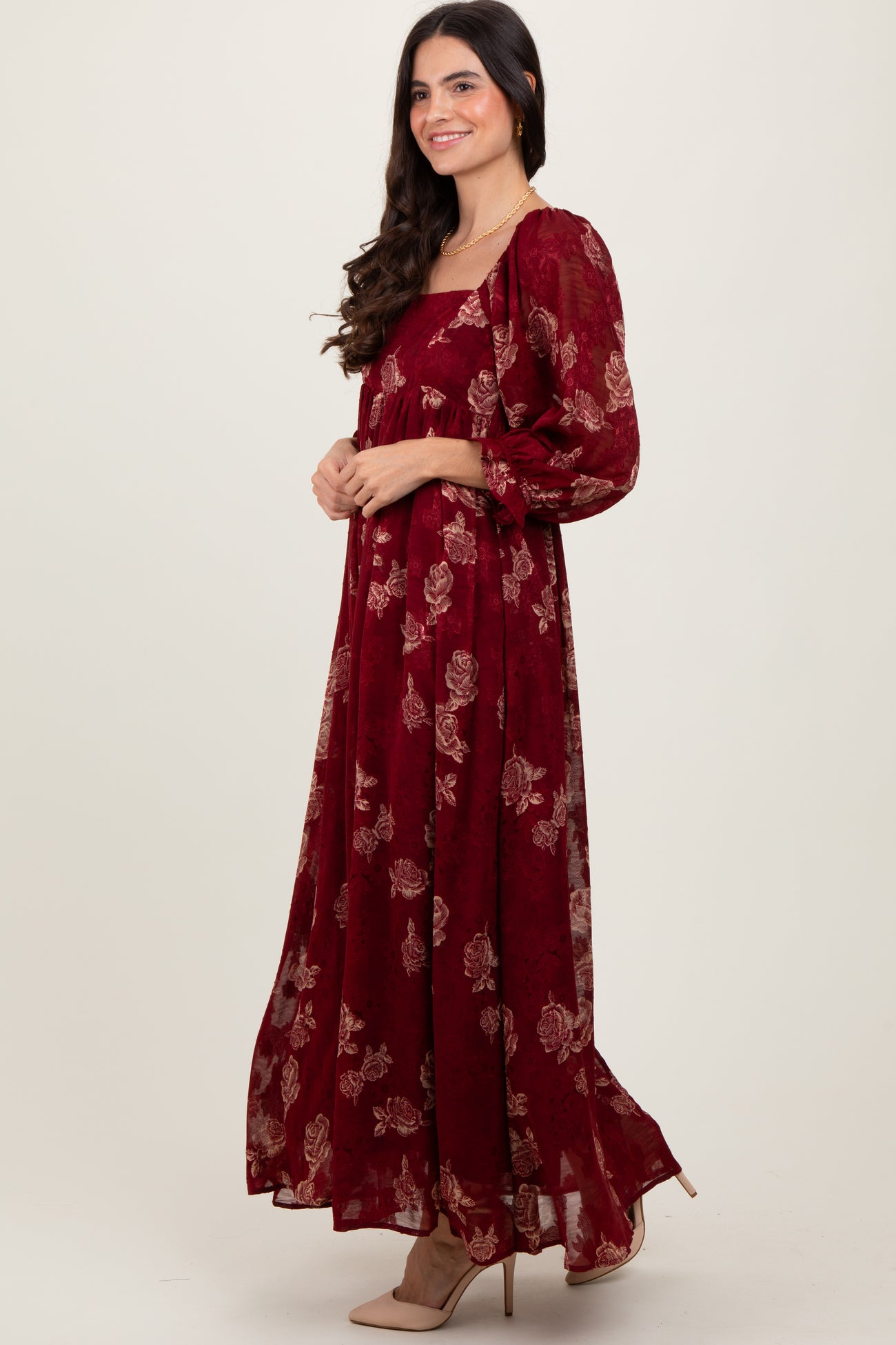 woman wearing a burgundy floral maxi dress with puff sleeves and a square neckline