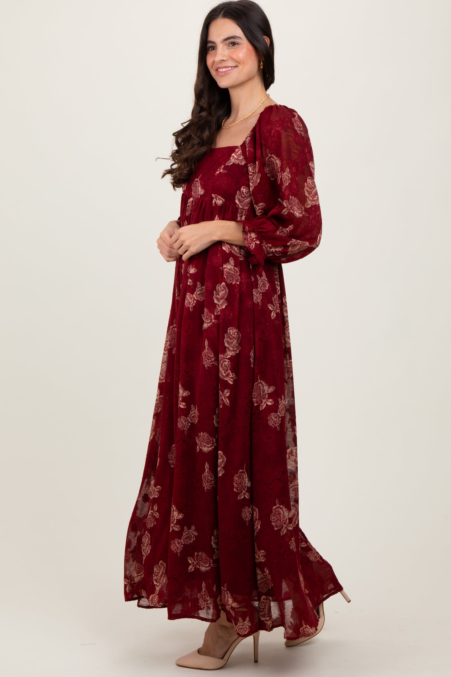 woman wearing a burgundy floral maxi dress with puff sleeves and a square neckline