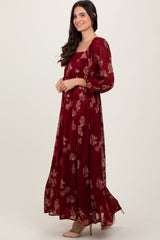 woman wearing a burgundy floral maxi dress with puff sleeves and a square neckline