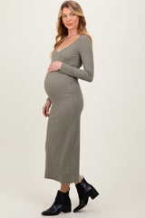 woman wearing a long sleeve olive green maternity dress and showcasing her baby bump