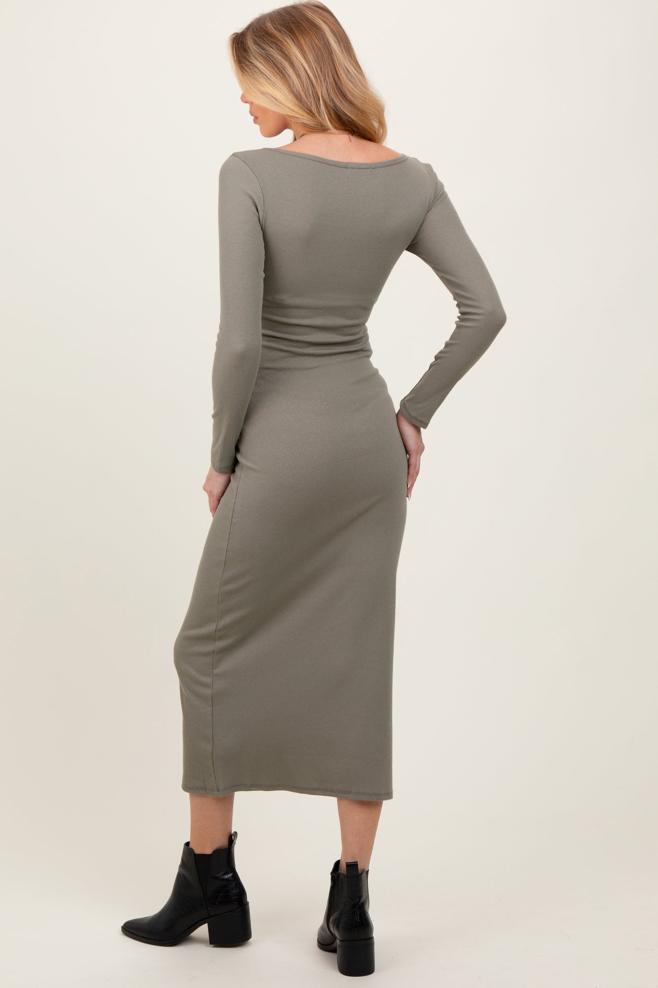 woman wearing a fitted olive green long sleeve maternity dress, showing her baby bump from the back