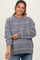 woman wearing a gray maternity sweater with white stripes and relaxed fit, smiling with hands on her belly