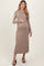 woman wearing a beige ribbed maternity dress and holding her baby bump