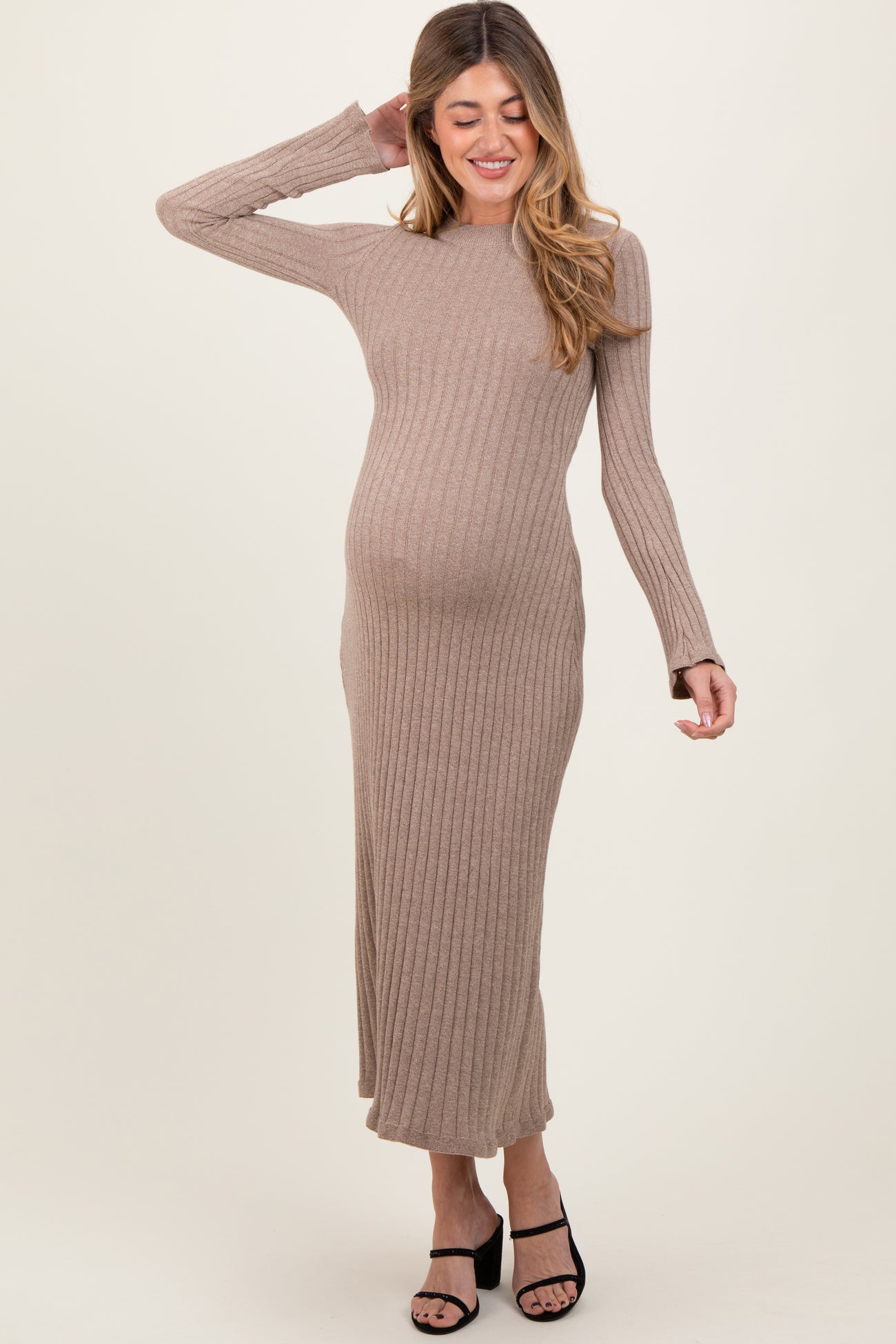woman wearing a taupe ribbed long sleeve maternity dress and showing her baby bump