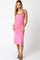 woman wearing a fitted pink midi dress with black trim and adjustable straps