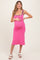 woman wearing a pink maternity dress with black trim, showing her baby bump