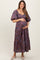woman wearing a purple floral print maternity maxi dress and holding her baby bump
