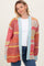 woman wearing a colorful oversized cardigan with red, orange, and blue details over a white top and jeans