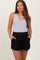 woman wearing a gray sleeveless maternity top and black maternity shorts with pockets