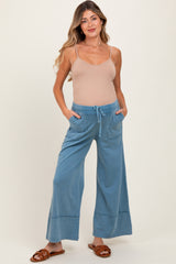 woman wearing light blue maternity wide-leg pants with pockets and a drawstring waist