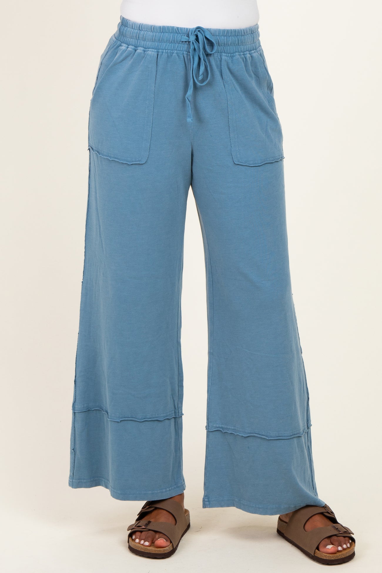 woman wearing a pair of light blue wide-leg pants with pockets and a drawstring waist