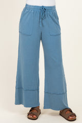woman wearing a pair of light blue wide-leg pants with pockets and a drawstring waist
