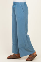 woman wearing relaxed fit blue wide-leg pants with pockets and drawstring waist, paired with brown sandals