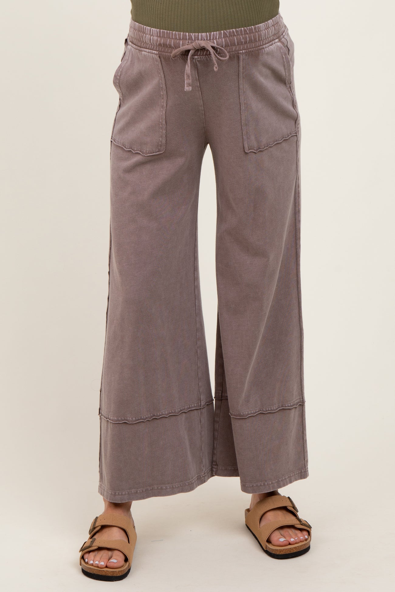 woman wearing light gray maternity wide-leg pants with pockets and drawstring waist, paired with brown sandals