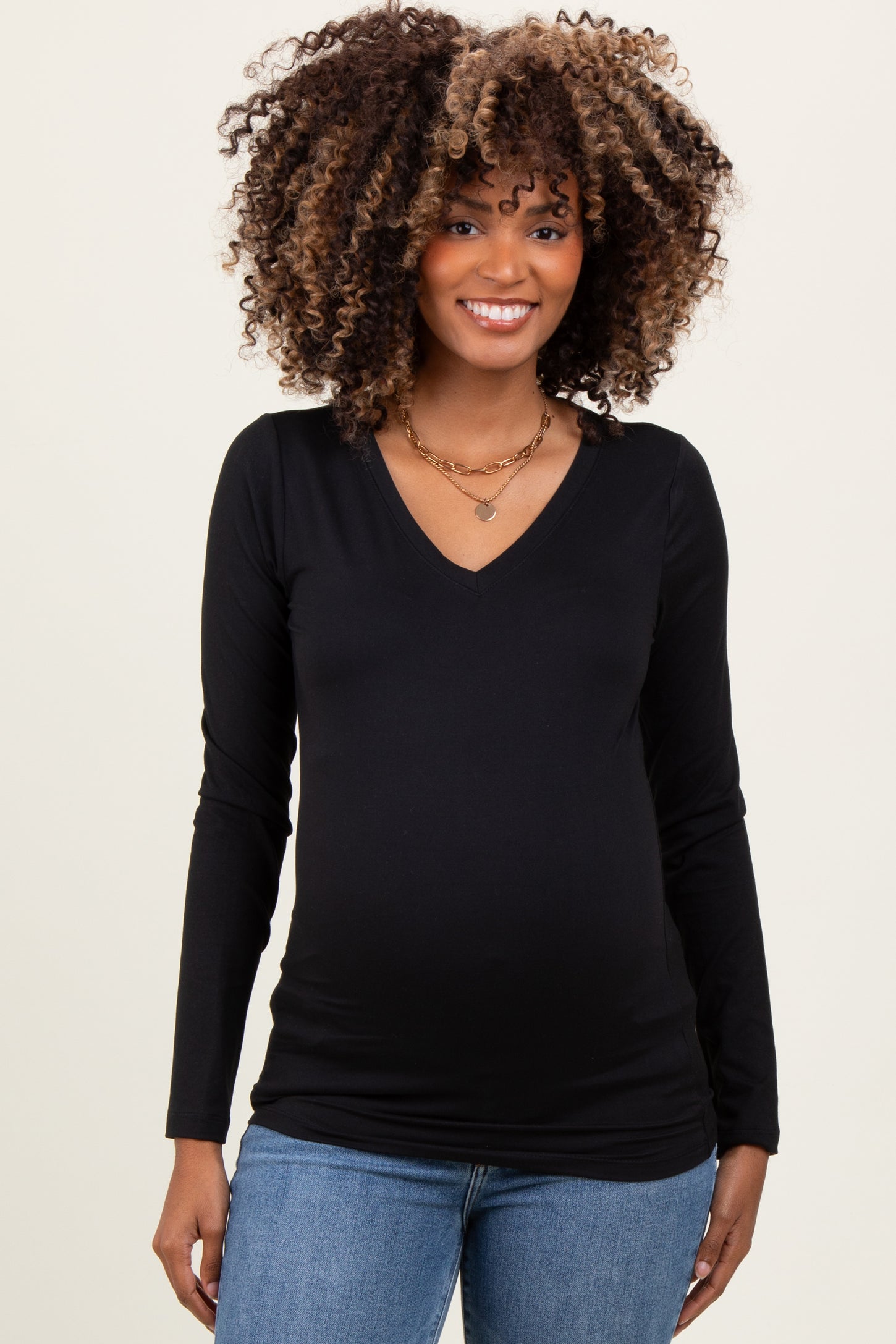 woman wearing a black long sleeve maternity top with a v-neck and visible baby bump