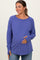 woman wearing a purple long sleeve maternity top and holding her baby bump