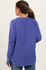 woman wearing a purple long sleeve maternity top, showing the back design, styled with relaxed fit