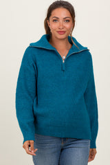 woman wearing a teal maternity pullover sweater with a half-zip and relaxed fit, showcasing her baby bump