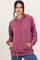 woman wearing a light pink ribbed hoodie with a front pocket and drawstring, styled with blue jeans