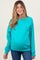 woman wearing a bright turquoise maternity sweatshirt and showing her baby bump