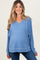 woman wearing a blue maternity sweatshirt with a v-neck and long sleeves, showing her baby bump