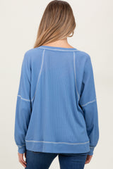woman wearing a light blue maternity sweatshirt with a relaxed fit and long sleeves, viewed from the back