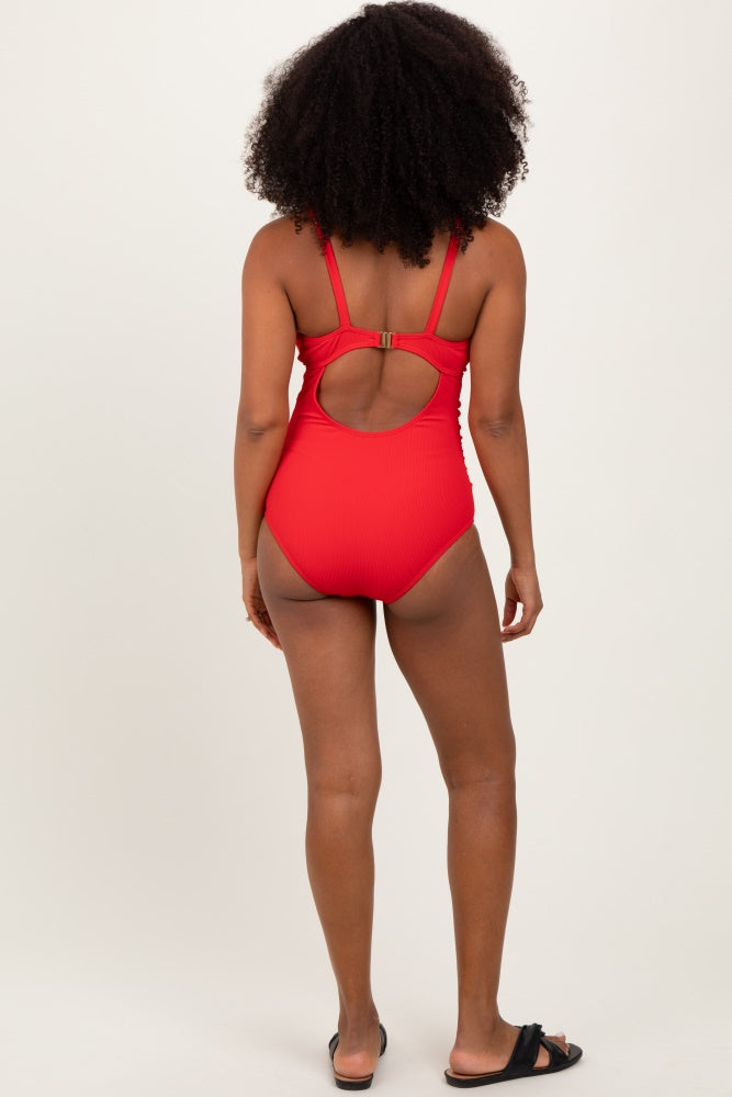woman wearing a red ribbed one-piece swimsuit with a cutout back and adjustable straps