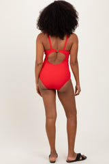 woman wearing a red ribbed one-piece swimsuit with a cutout back and adjustable straps