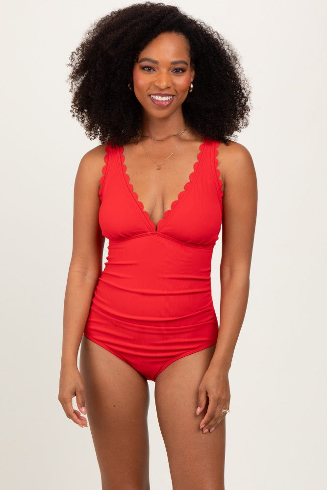 woman wearing a red scalloped edge one-piece swimsuit with a plunging neckline and a fitted silhouette