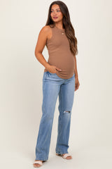woman wearing a brown sleeveless maternity tank top and blue distressed maternity jeans, showing her baby bump