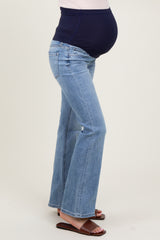 woman wearing light blue maternity flared jeans with a navy blue over-the-bump waistband and visible baby bump