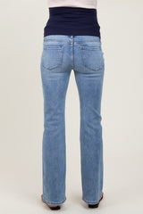 woman wearing a pair of light blue maternity jeans with a dark blue belly panel, shown from the back