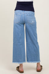 woman wearing light blue maternity wide-leg jeans with a distressed hem, showing a baby bump from behind