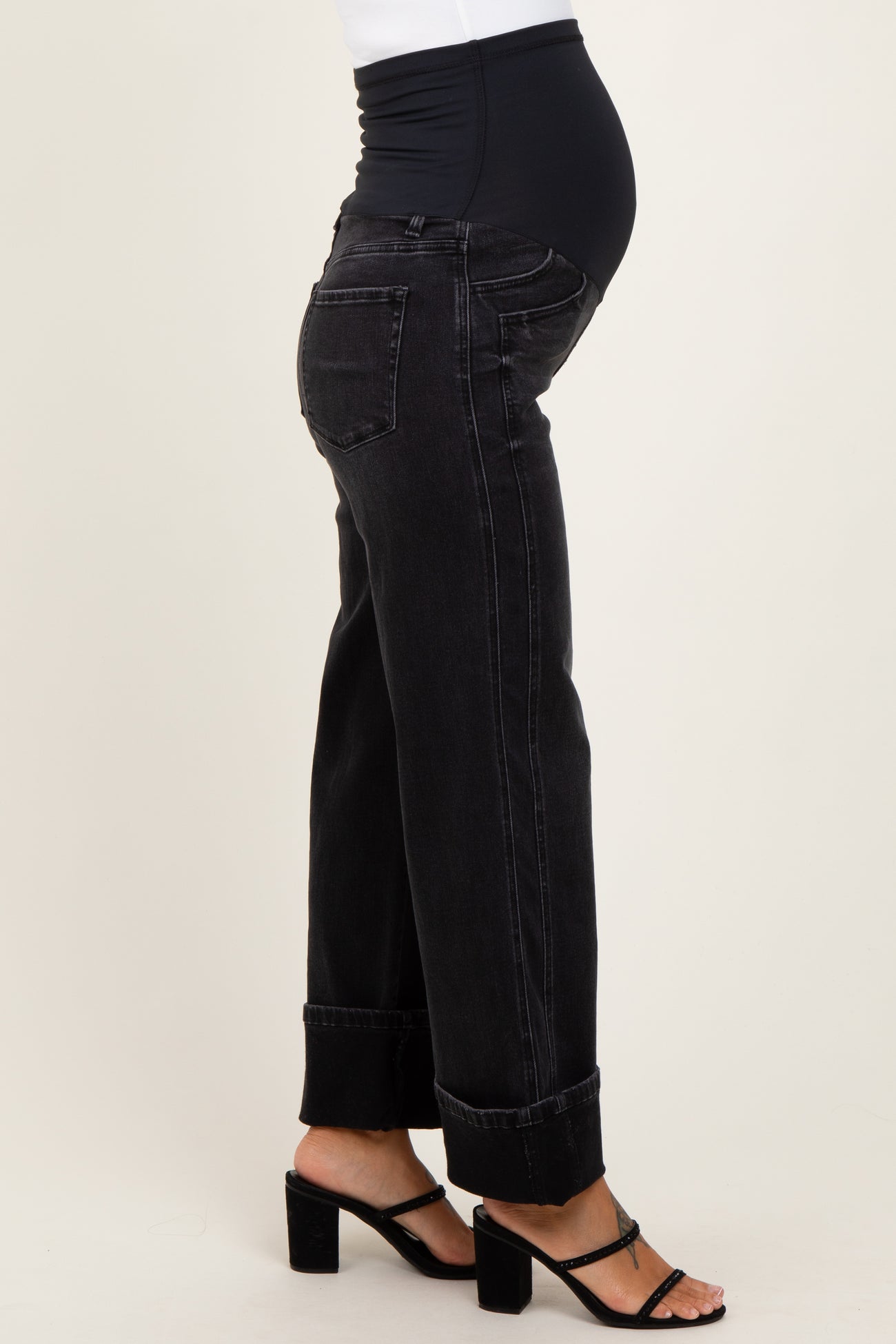 maternity wear black denim jeans with a wide leg fit, model showing baby bump and wearing strappy heels