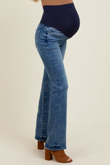 woman wearing a pair of light blue maternity jeans with a high waistband and a visible baby bump