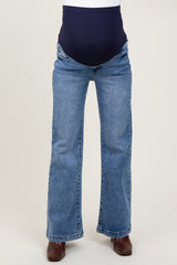 maternity wear blue flared jeans with a dark blue over-the-bump waistband, model wearing the jeans
