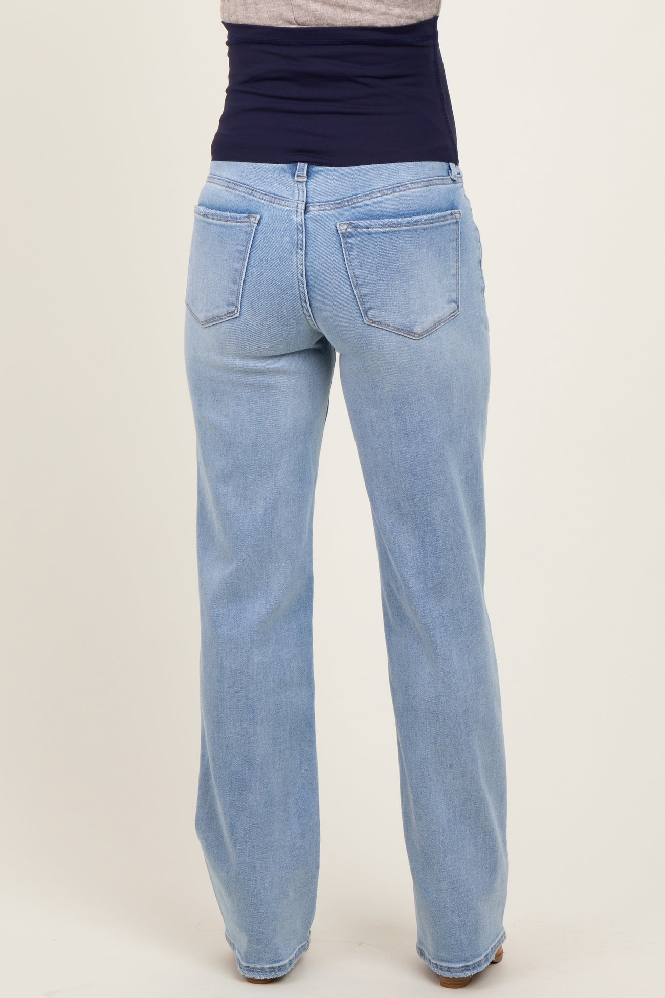 maternity wear light blue wide leg jeans with a supportive belly band visible from the back