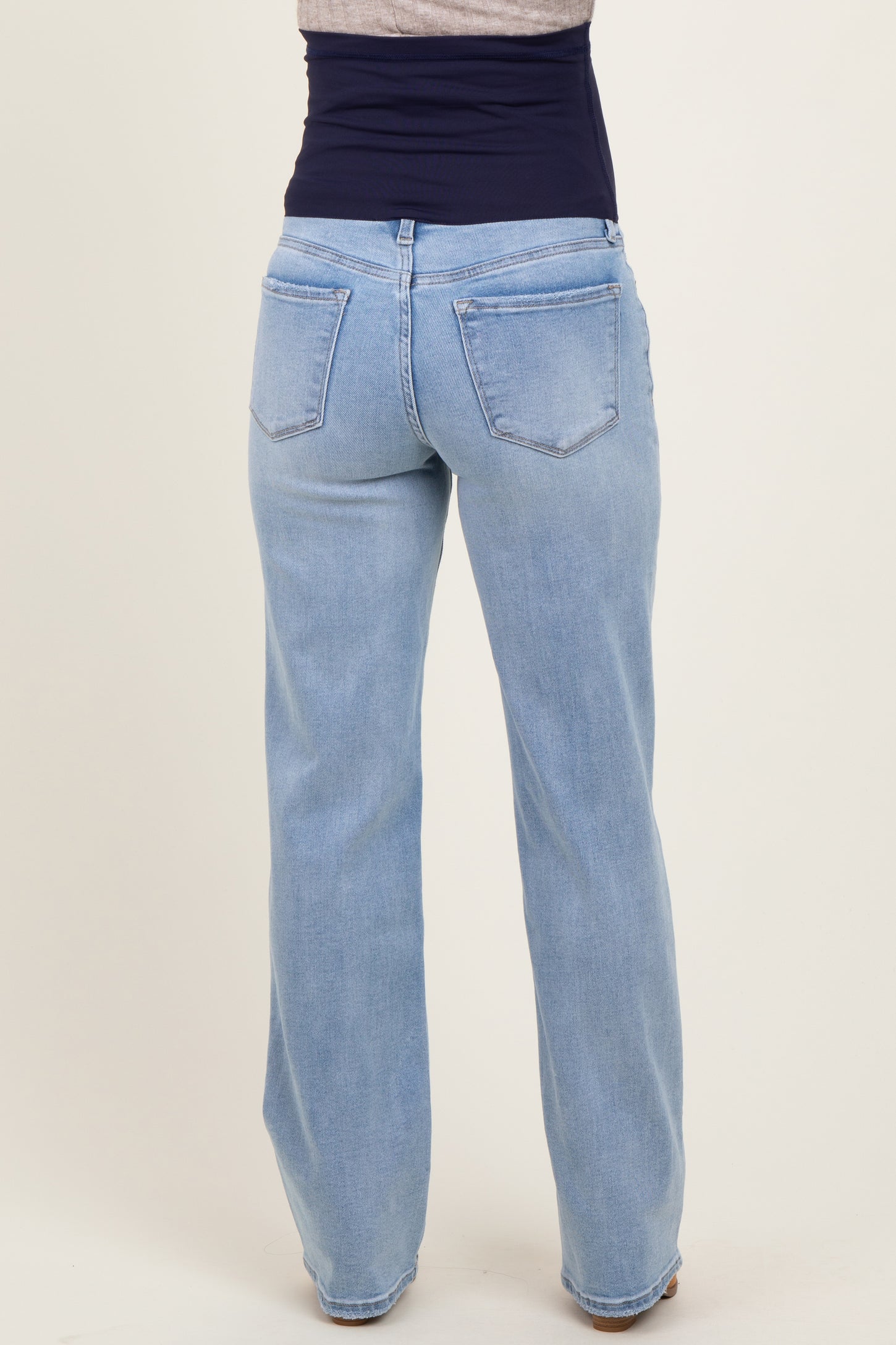 maternity wear light blue wide leg jeans with a supportive belly band visible from the back