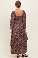 woman wearing a brown floral maxi dress with a smocked bodice and tiered ruffle hem, shown from the back