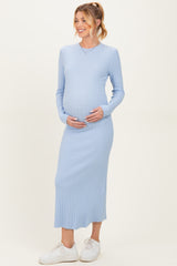 woman wearing a light blue ribbed long sleeve maternity dress and holding her baby bump