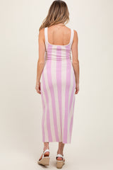 woman wearing a pink and white striped maternity dress with a fitted silhouette and scoop back design, showing baby bump