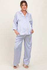 woman wearing a light purple maternity pajama set with a button-up top and wide-leg pants, showing her baby bump