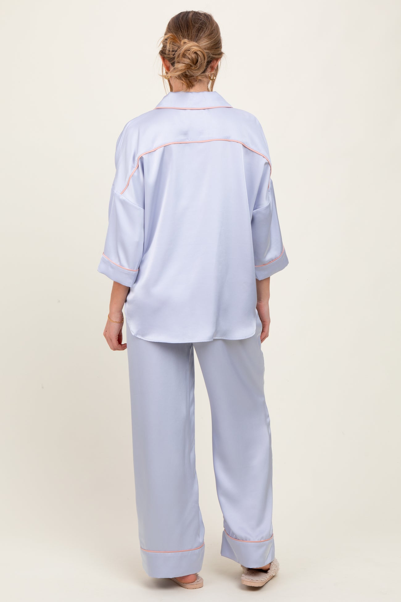 woman wearing a light blue maternity pajama set with a loose top and wide-leg pants, viewed from the back