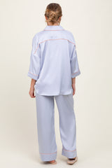 woman wearing a light blue maternity pajama set with a loose top and wide-leg pants, viewed from the back