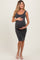woman wearing a dark gray ribbed knit maternity dress and holding her baby bump