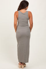 woman wearing a striped gray maternity maxi dress, showing a fitted silhouette from the back