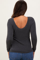woman wearing a dark gray maternity top with a low back and long sleeves, viewed from the back