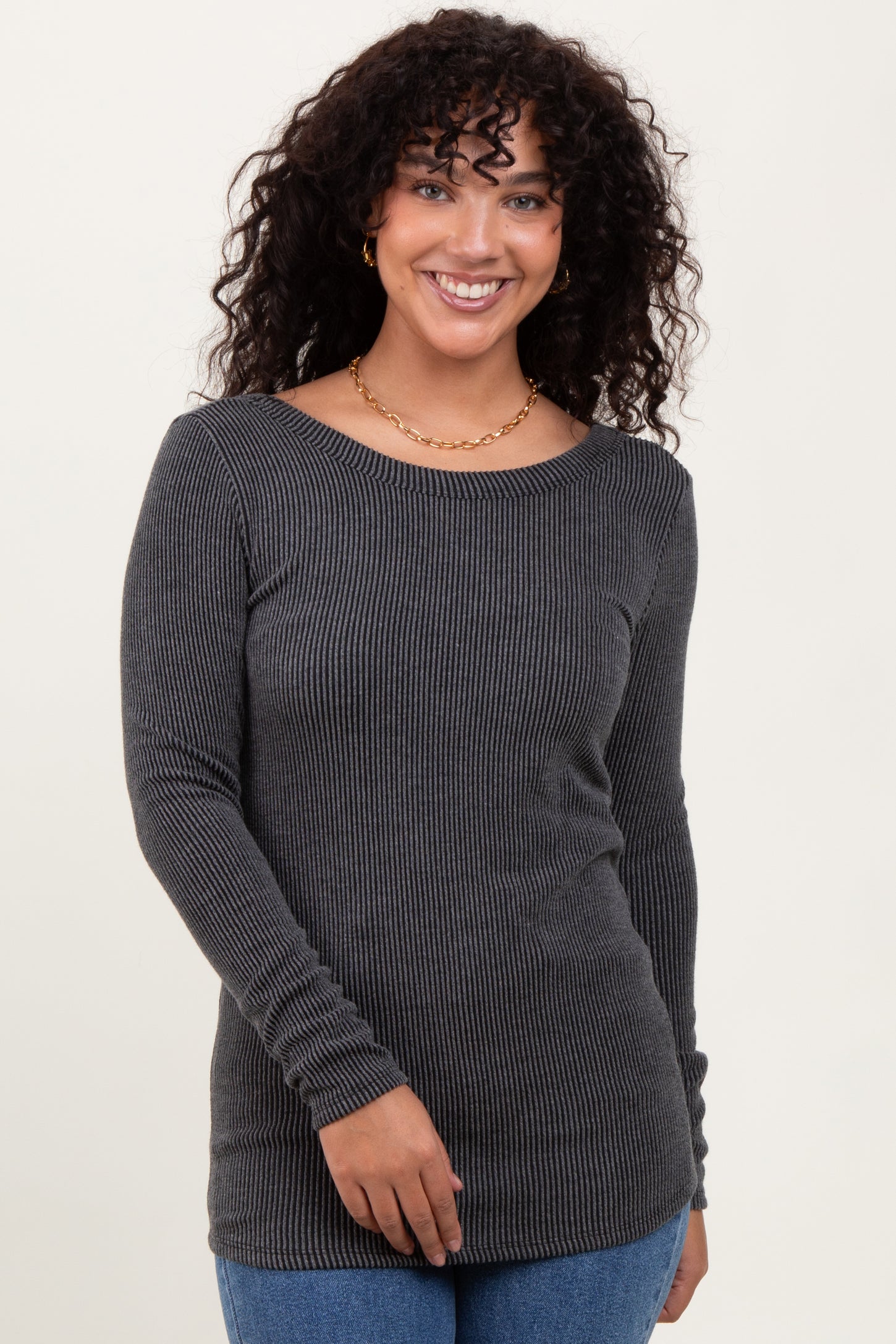 woman wearing a dark gray ribbed long sleeve top with a round neckline and a fitted silhouette