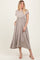 woman wearing a beige short sleeve midi dress with an elastic waist and side pockets