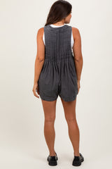 woman wearing a gray maternity romper with pleated back details, showing a side view of the garment